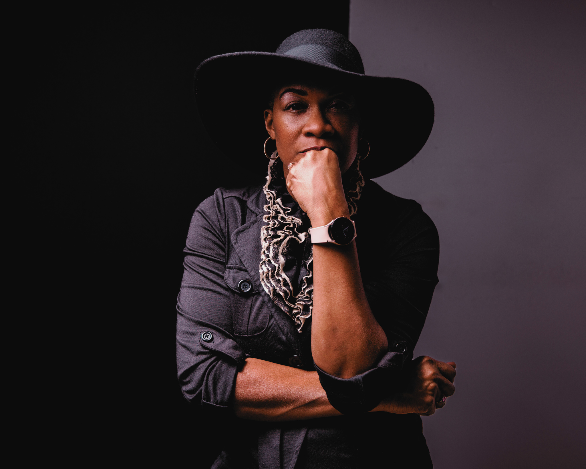 Gwendolyn R. Houston-Jack an African American woman who is a small business owner, creative, and podcaster is wearing a black hat and a scarf.